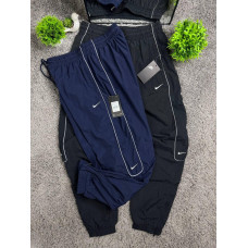 Чоловічі спортивні штани Nike Reflective широкі чорні / темно-сині з рефлективним кантом, вишитим логотипом і бирками